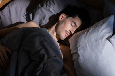 Man sleeping in bed in a dark room