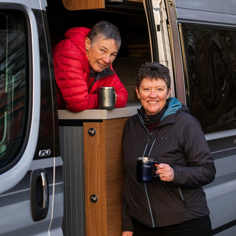 Happy Couple standing in RV with coffee cups in their hands