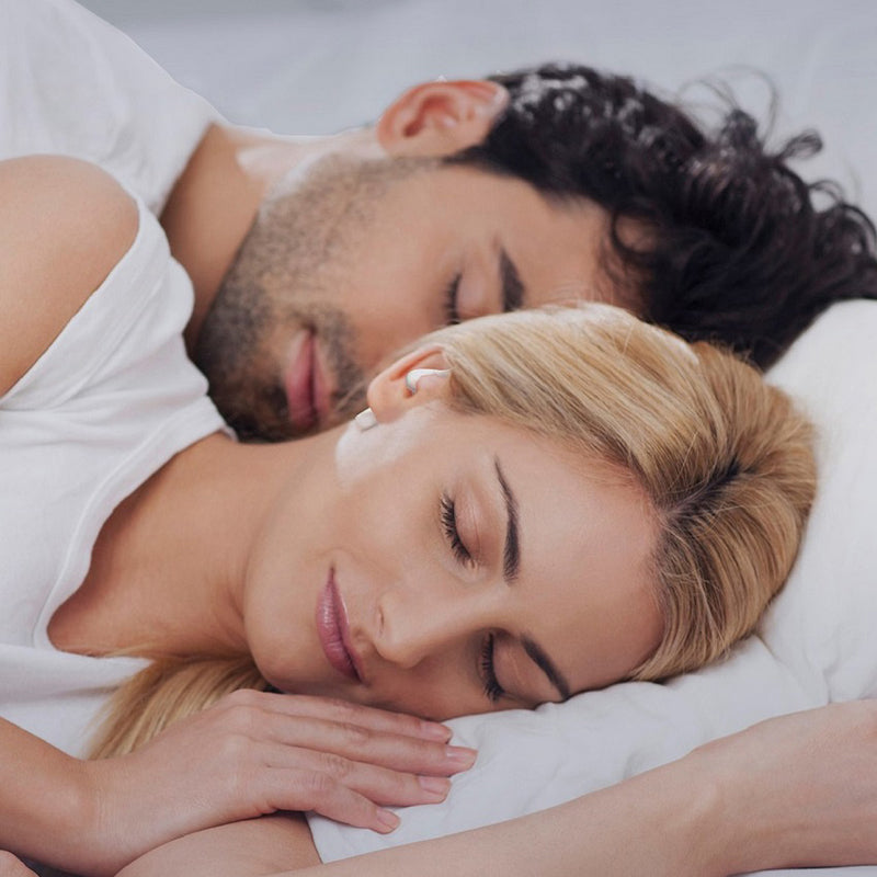 Close up of couple sleeping. Woman is wearing SoundOff earbuds.
